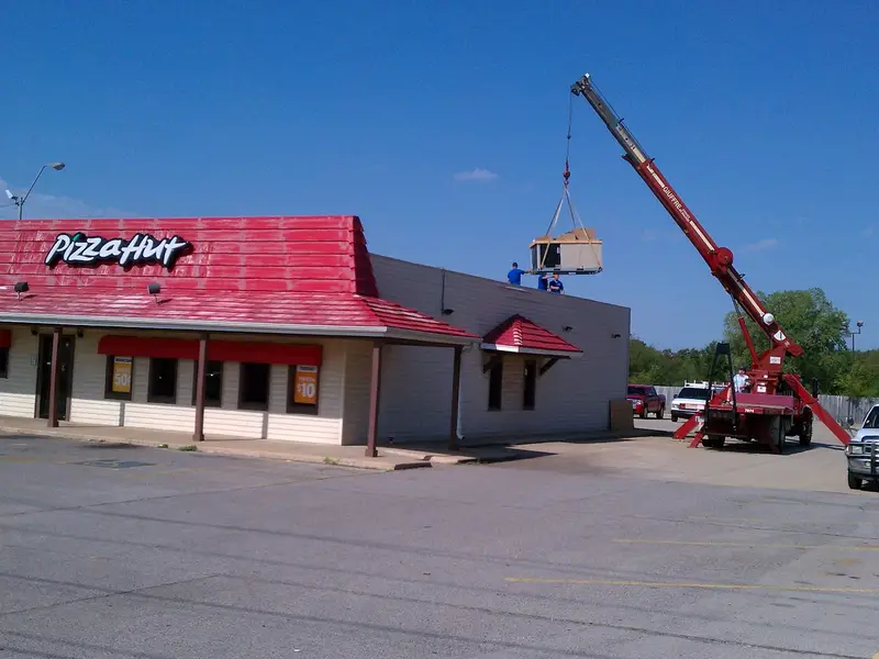 Crane setting a rooftop unit on a restaurant